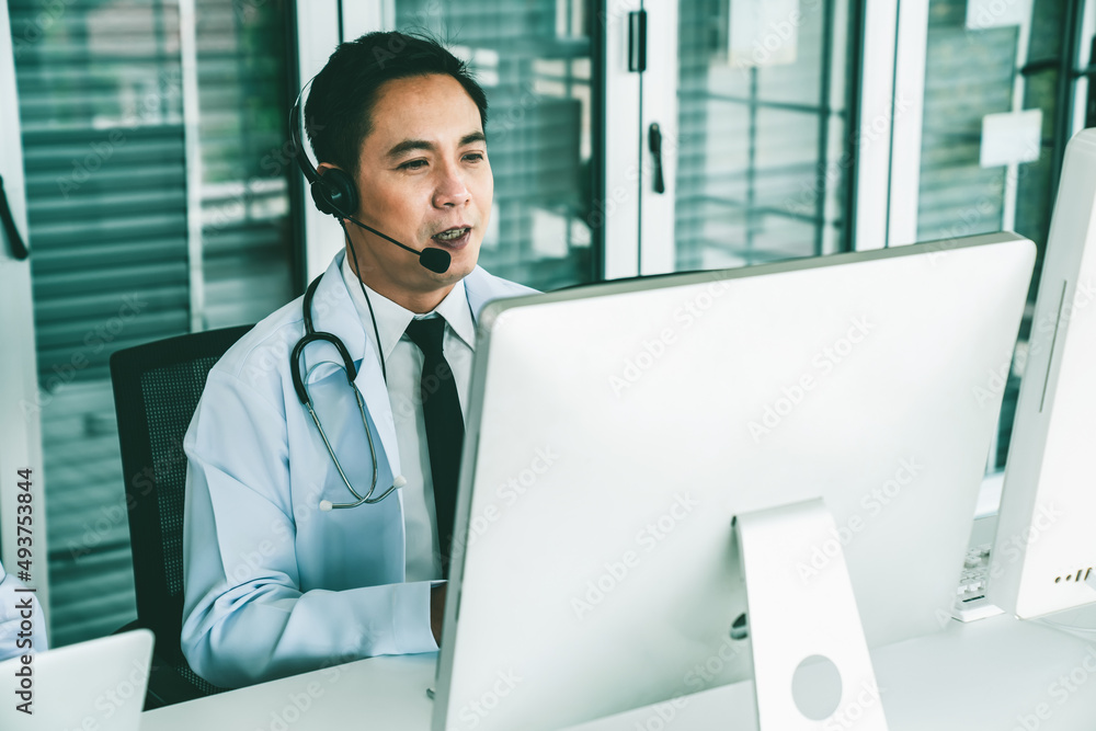 Doctor wearing headset talking actively on video call in a clinic or hospital . Concept of telehealt