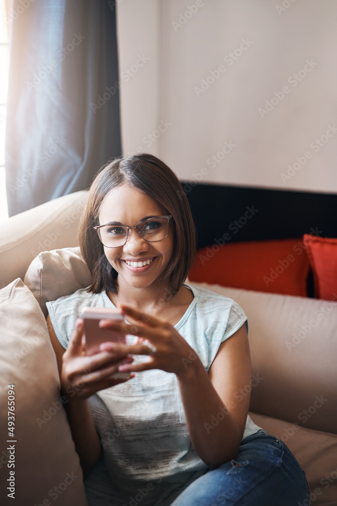 Texting and relaxing. Cropped shot of an attractive young woman using a cellphone at home.