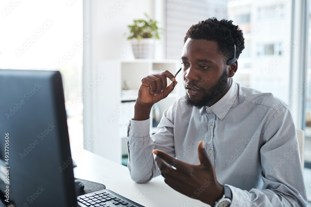 Providing helpful step-by-step instructions to a caller. Shot of a young call centre agent working o