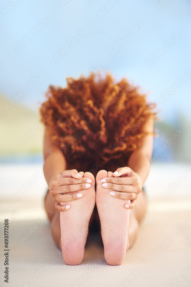 Find peace in the chaos. Shot of a young woman practicing her yoga routine.