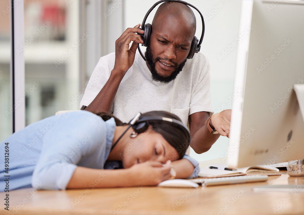 My coworker really needs a break. Shot of a male colleague looking on as his coworker sleeps.