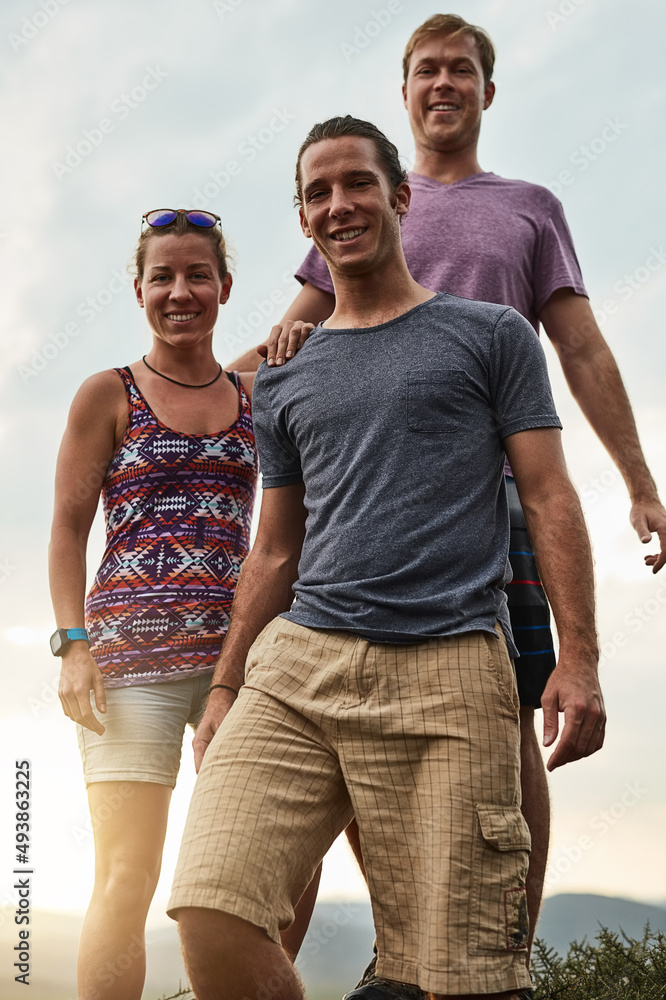 Finding happiness in hiking. Portrait of three happy friends posing together during a hike in the mo