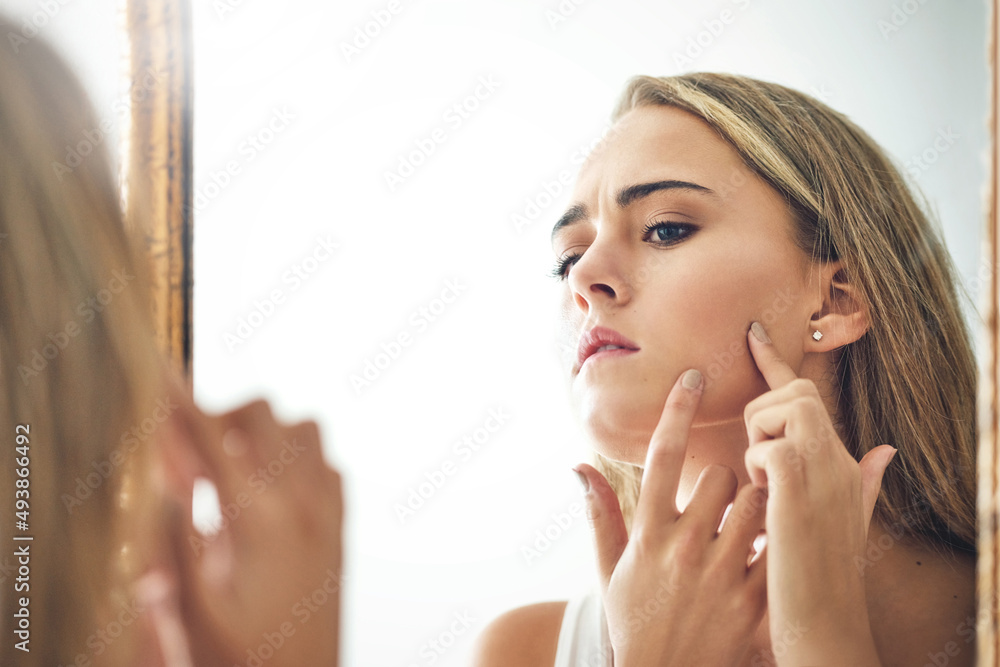 I wont allow you to ruin my day. Cropped shot of an attractive young woman popping a pimple.