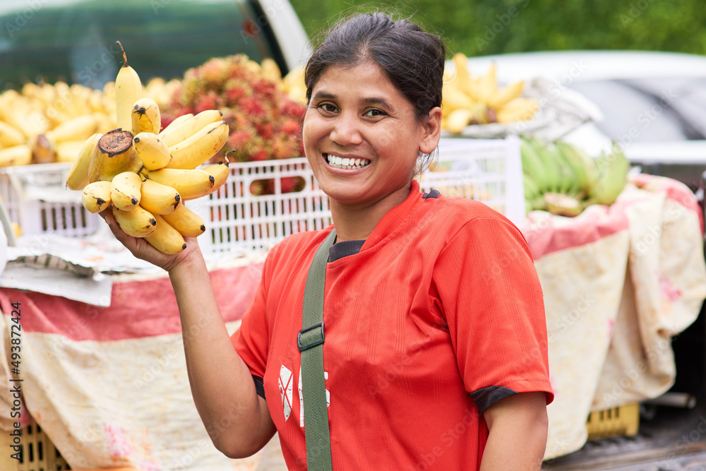 I only sell the freshest of produce. Portrait of a woman selling bananas at her market stall outside