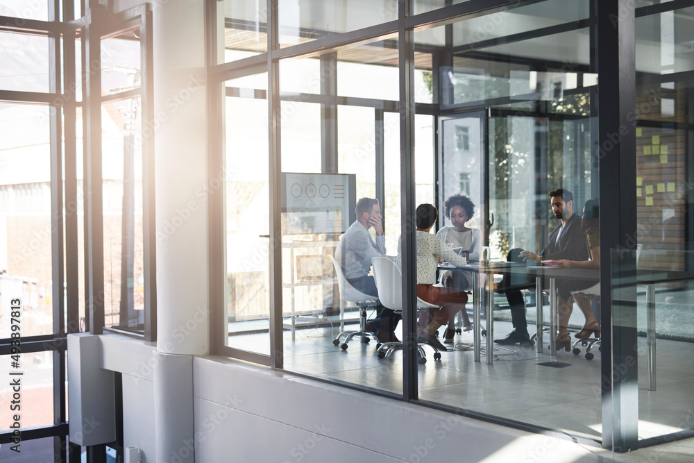 Handling their business in the boardroom. Full length shot of a group of businesspeople meeting in t