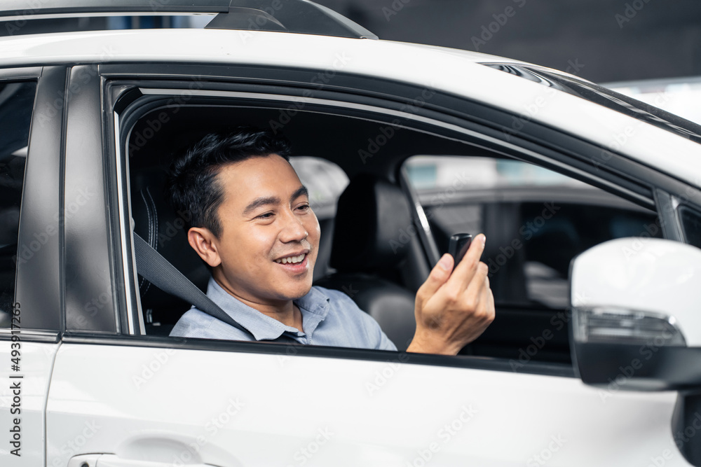 Asian attractive man customer hold remote car key while sit in vehicle. 