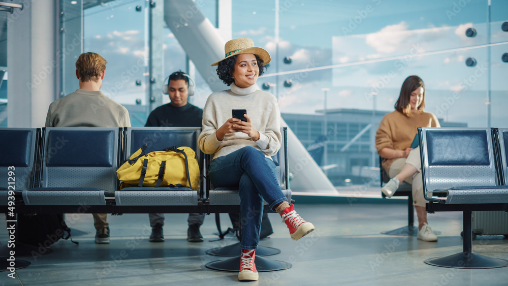 Airport Terminal: Diverse Multi-Ethnic Crowd of People Wait for their Flights, Use Mobile Smartphone