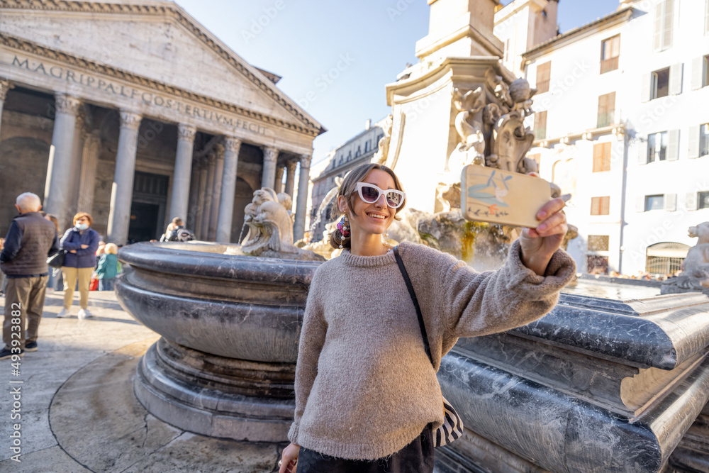 年轻的女旅行者在罗马著名的万神殿和喷泉前自拍。