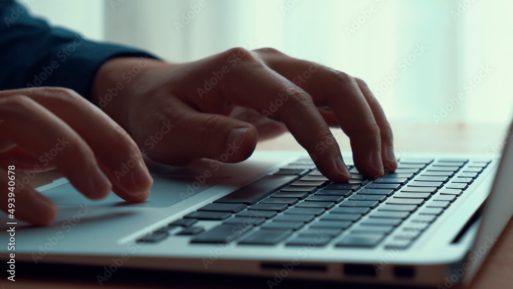 Businessman hand work on capable laptop computer at office table close up shot and selective focus a