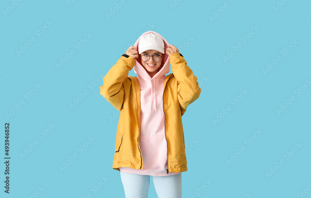 Beautiful young woman in stylish clothes on color background