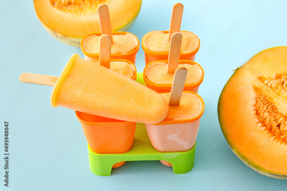 Tasty melon popsicles on blue background