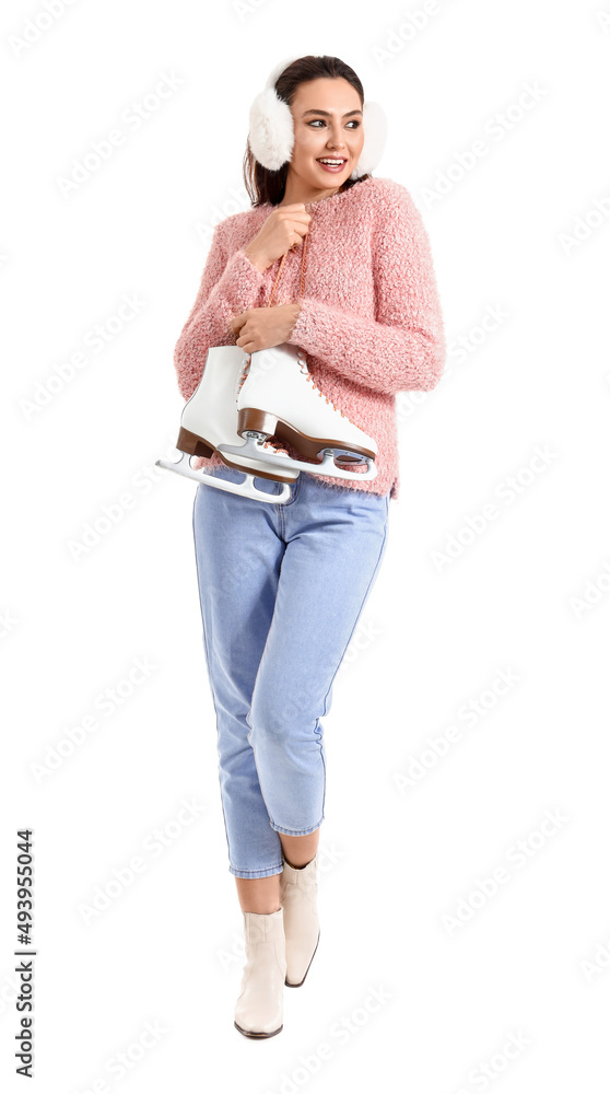 Young woman in earmuffs with ice skates on white background