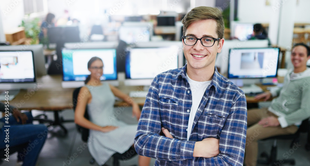 My team and I have got it all covered. Portrait of a smiling young designer standing in an office wi