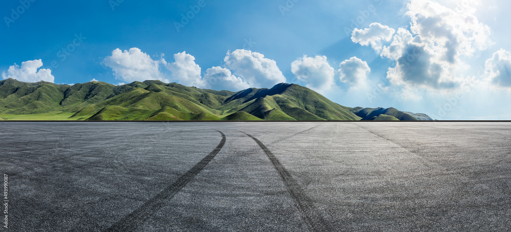 空旷的柏油路和蓝天下的山地自然风光。道路和山脉的背景。