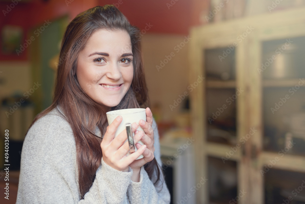 The perfect pick-me-up. Portrait of a beautiful young woman enjoying a cup of coffee at home.