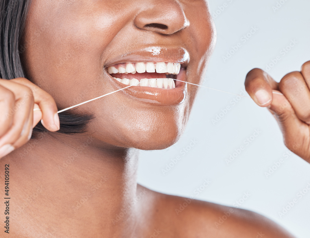 A smile is a beautiful thing, keep it that way. Studio shot of an attractive young woman flossing he