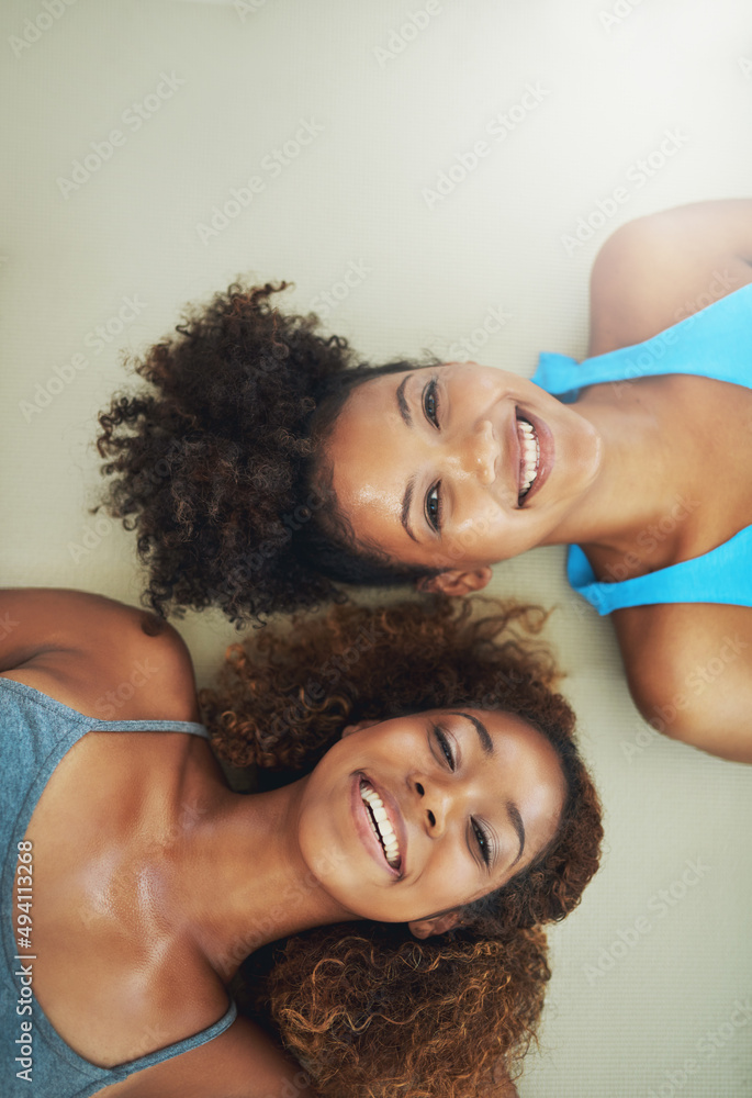 Well...that was fun. High angle portrait of two young women lying on the floor after yoga class.