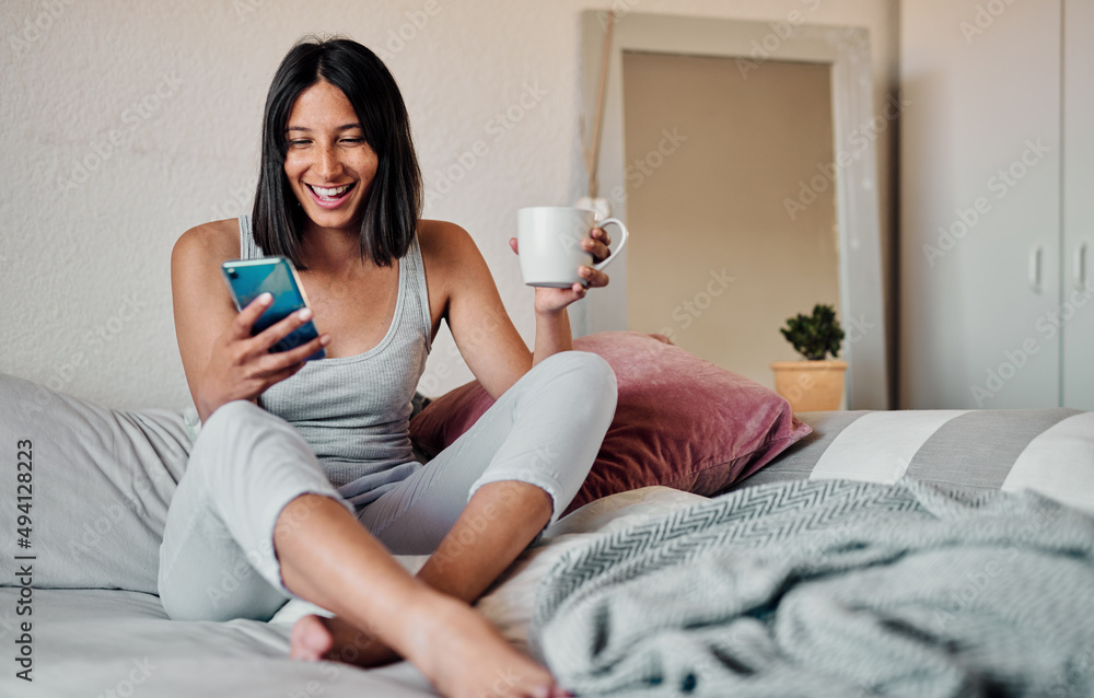 Mornings are for coffee and social media. Shot of a young woman using a smartphone and enjoying a cu