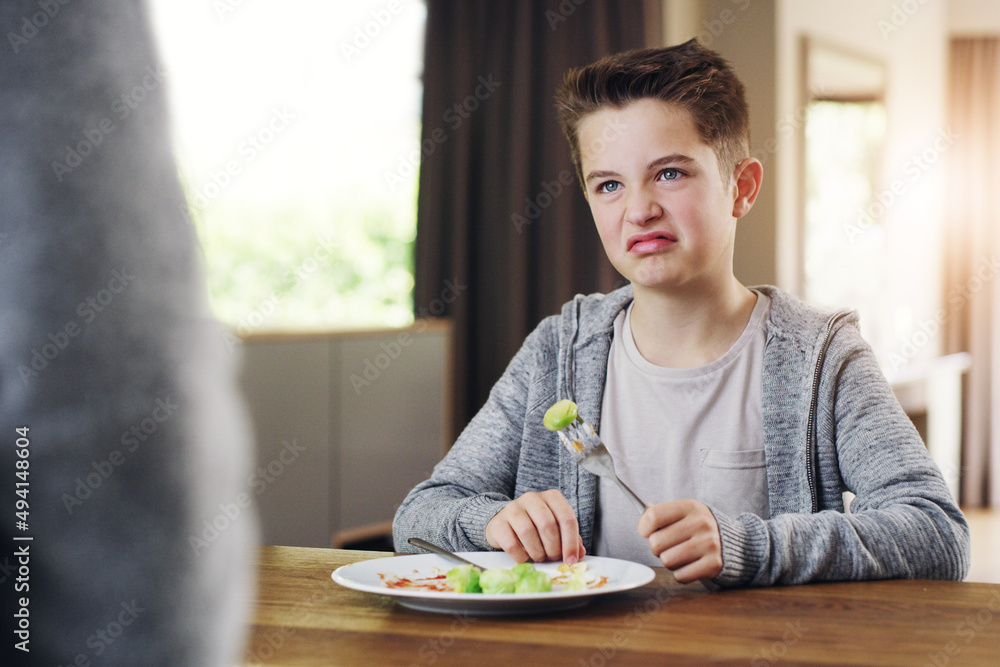 Id rather go to bed hungry. Shot of a young boy refusing to eat his brussels sprouts at home.