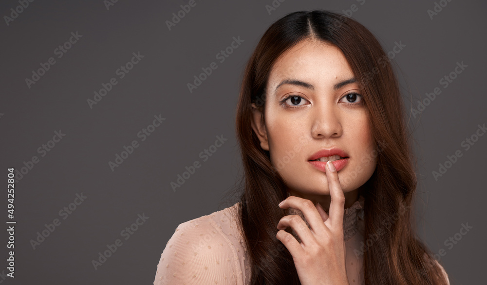 Own your beauty. Cropped portrait of an attractive young woman posing in studio against a grey backg