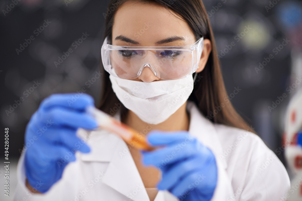 Finally the compound is complete. Shot of a female scientist observing a sample in a test tube.