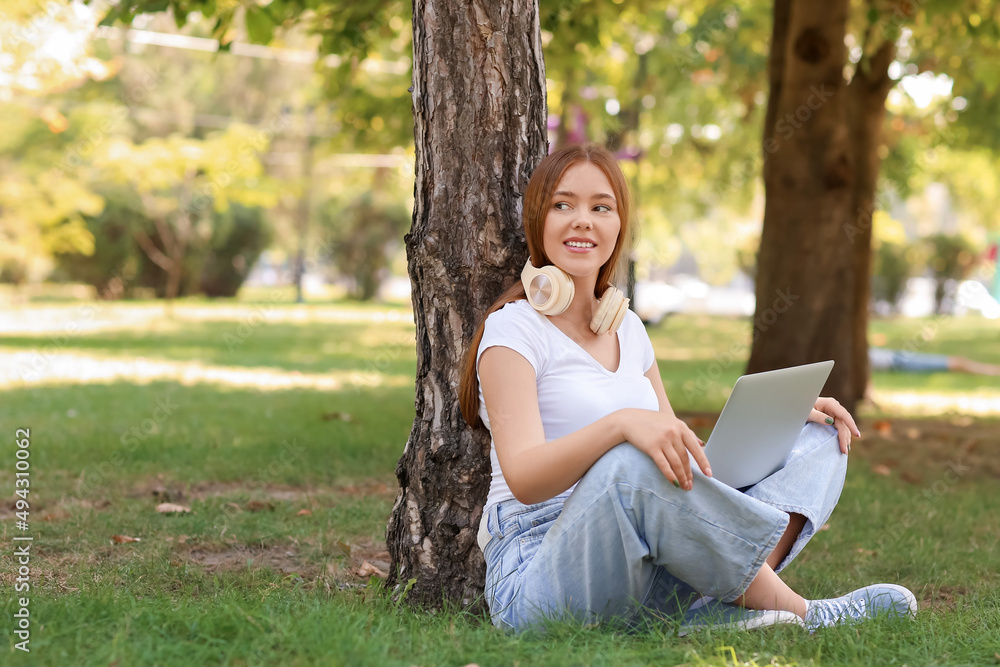 Cool young woman with laptop in park