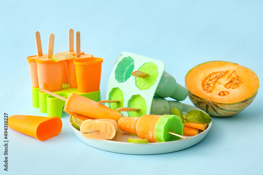 Plate with tasty melon popsicles on blue background