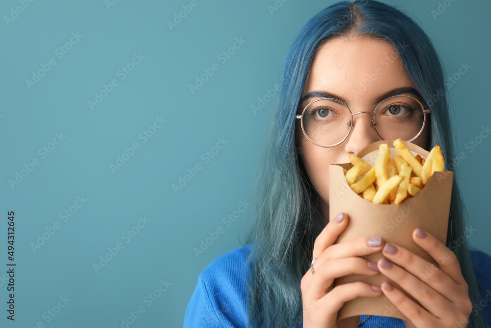 Young woman with unusual hair and french fries on color background