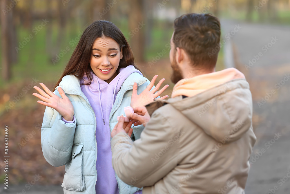 年轻人在森林里向他惊讶的女友求婚