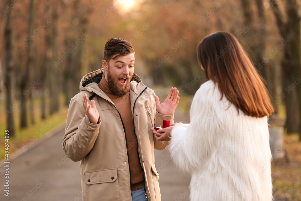 一名年轻女子在公园向她惊讶的男友求婚