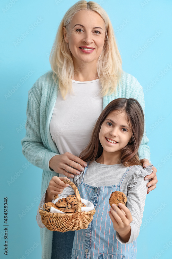 成熟的女人，她的小孙女和蓝底饼干篮子