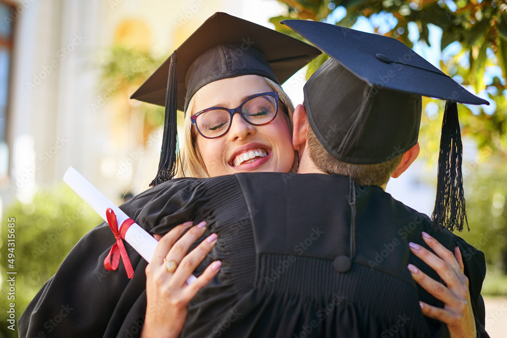 Celebrating our big accomplishment. Shot of a young couple embracing each other on graduation day.