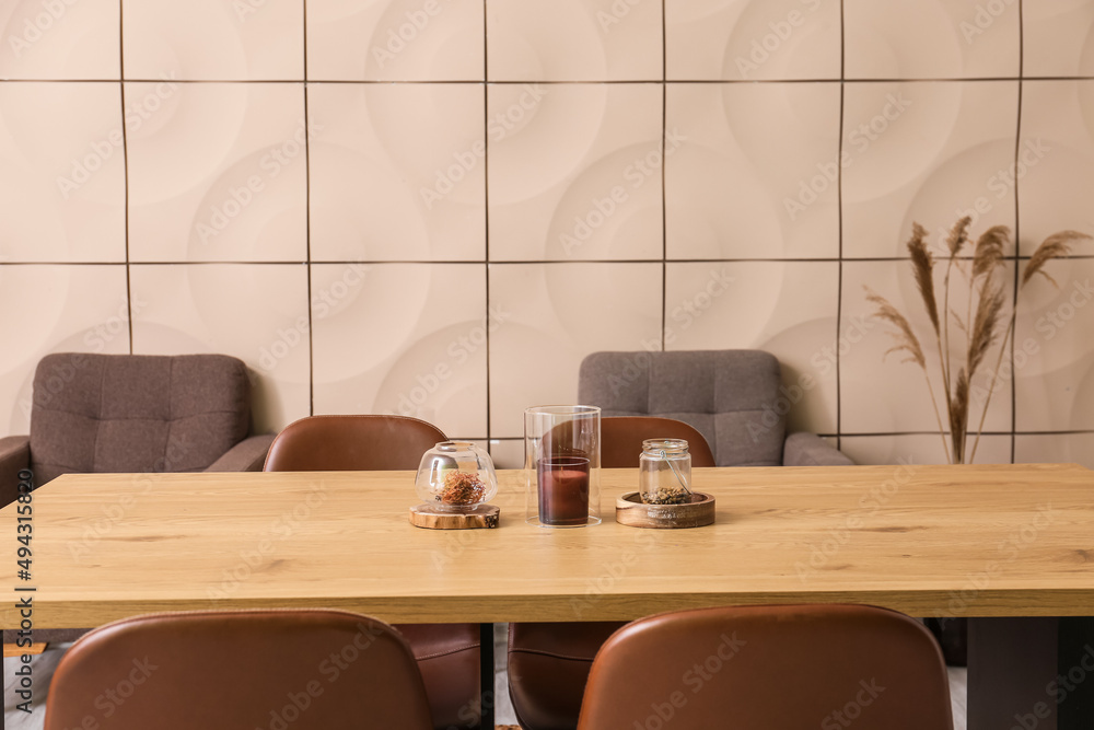 Stylish decor with candle on wooden table in dining room