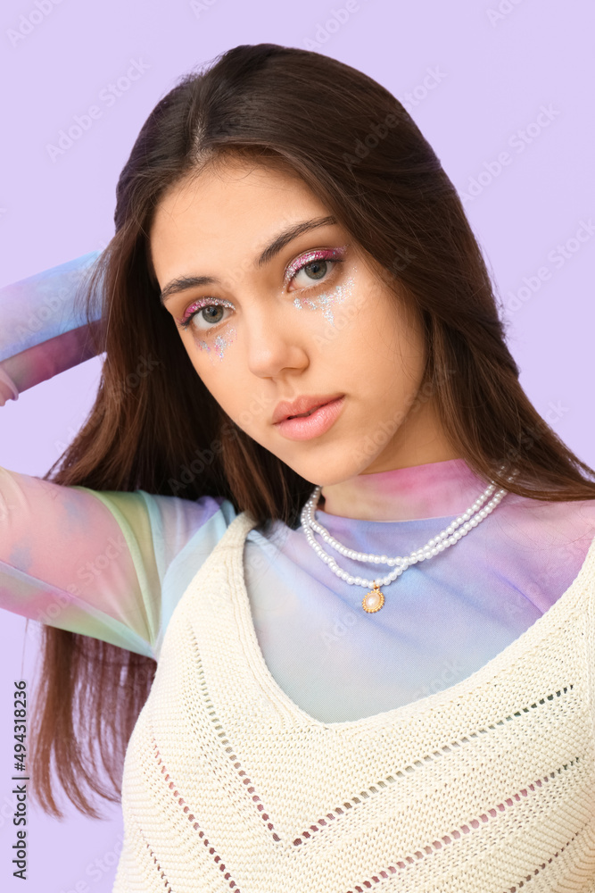 Portrait of fashionable woman with creative makeup on color background