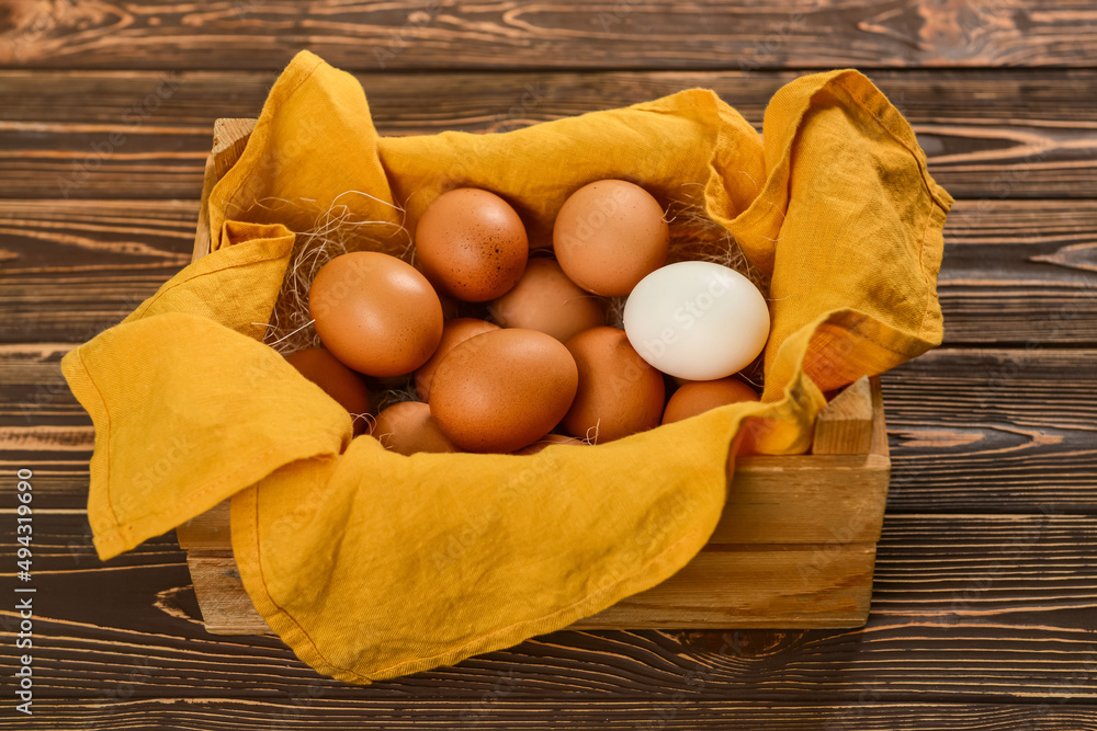 Box with fresh chicken eggs on wooden background