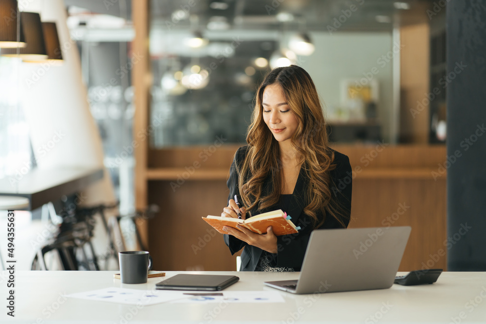 Business asian woman taking note on note book, Attractive girl working with laptop computer