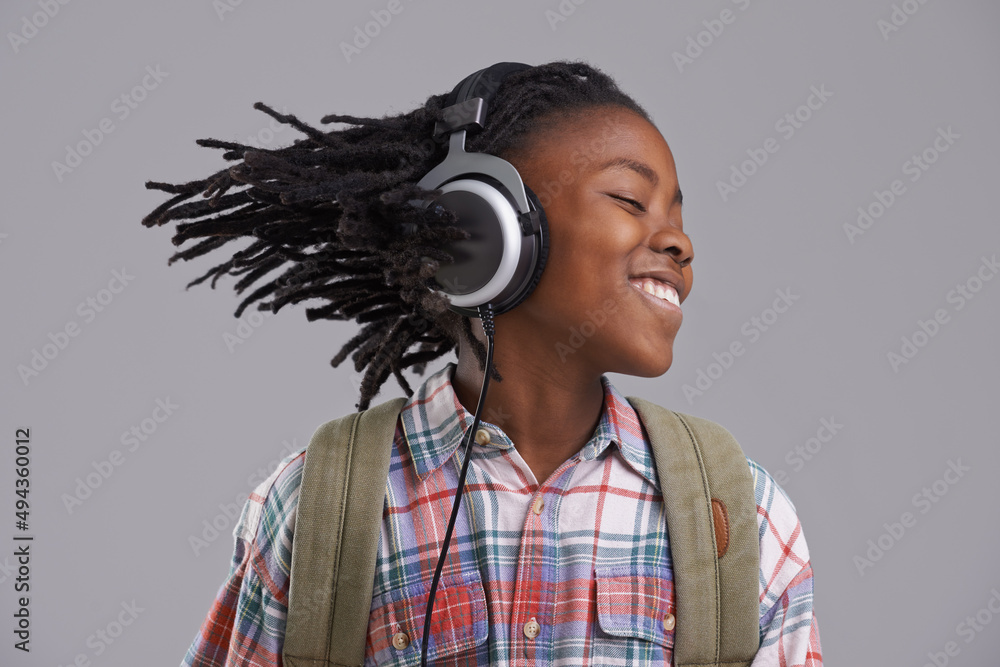 Moving to beat. An African-American boy listening to music over his headphones.