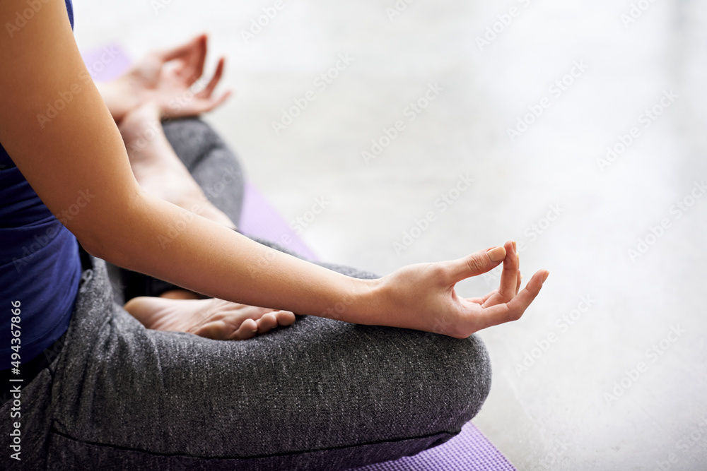 Finding inner peace. Cropped shot of a woman practicing yoga at home.