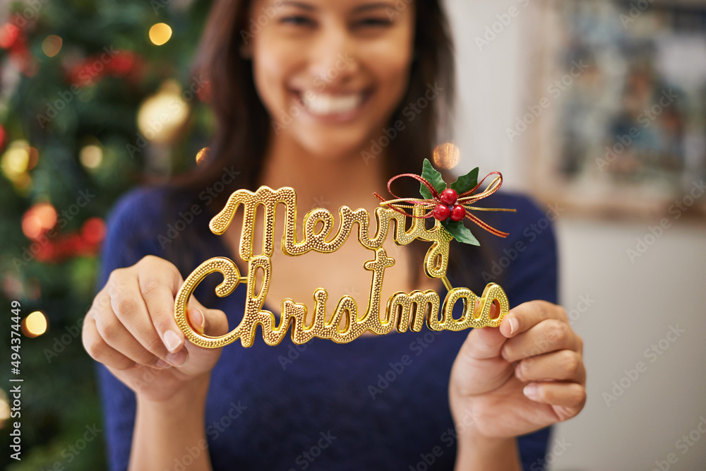 Spreading a little festive cheer. Cropped shot of a beautiful young woman holding up a festive decor