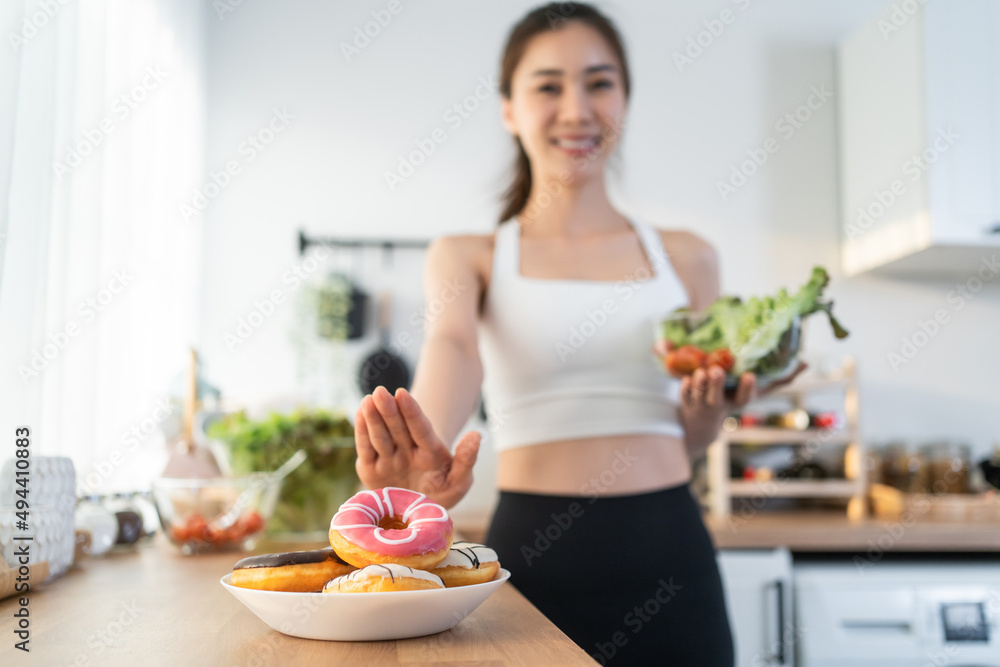 亚洲有魅力的活跃女性在家里的厨房里拿着一个可吃的碗。