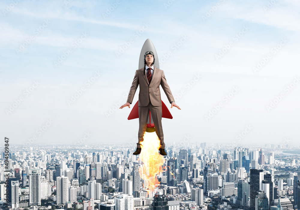 Businessman in aviator hat flying on rocket