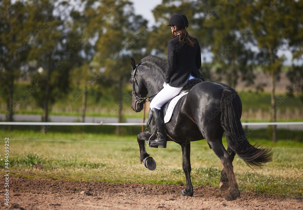 And shes off. Rearview shot a young female jockey riding her horse out on the farm.