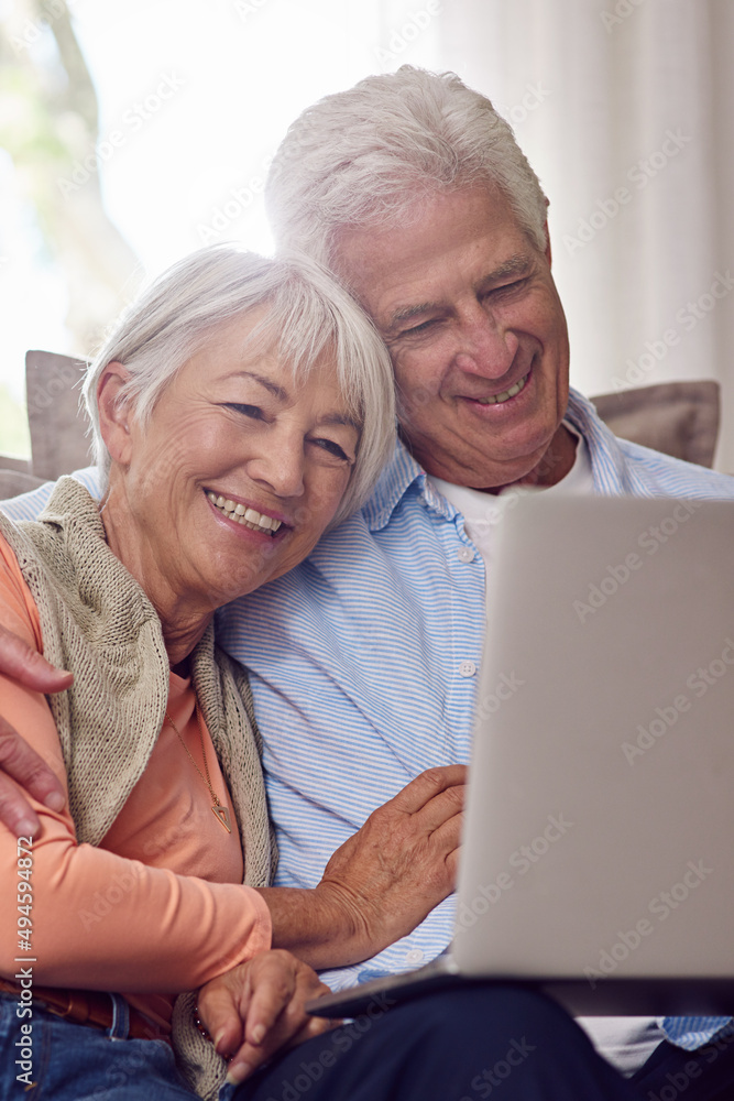 Watching romantic comedies online. Shot of a senior couple using a laptop at home.