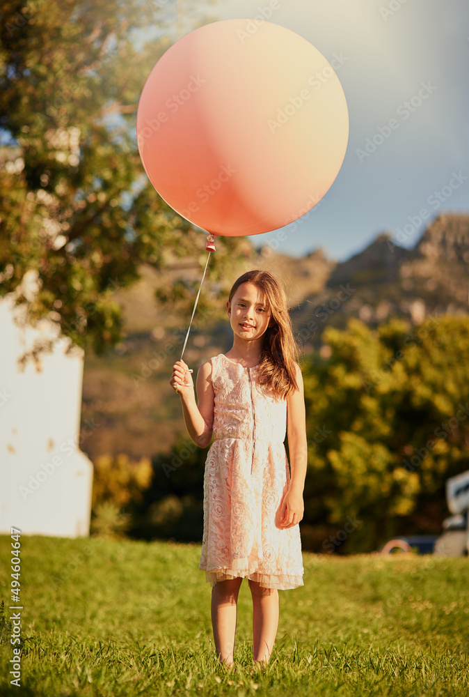 Any bigger and it would carry me away. Portrait of a cute little girl holding a huge balloon while s