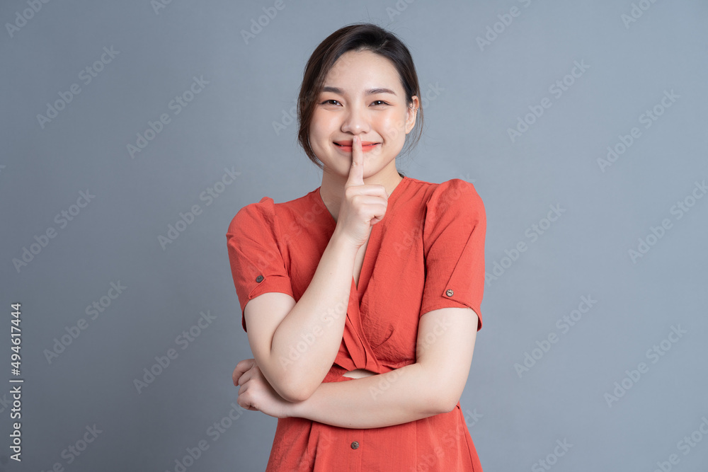 Young Asian woman posing on gray background