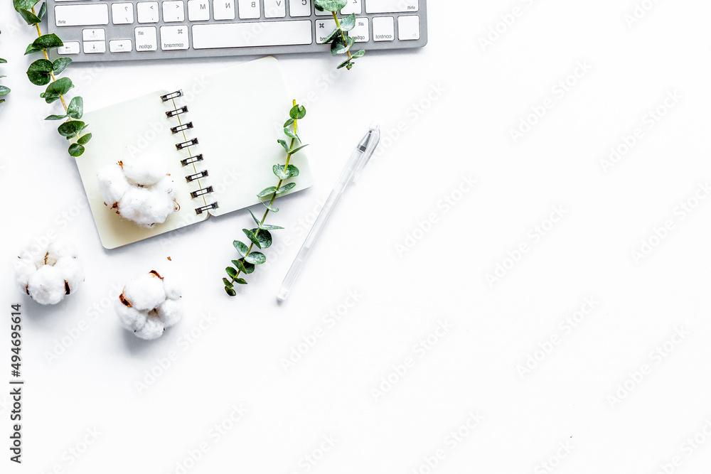 Laptop, cotton branch on white table. Flat lay, top view minimal freelancer home office desk workspa