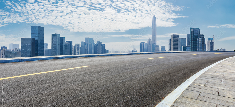 中国深圳的沥青道路和城市天际线，以及现代化的商业建筑。