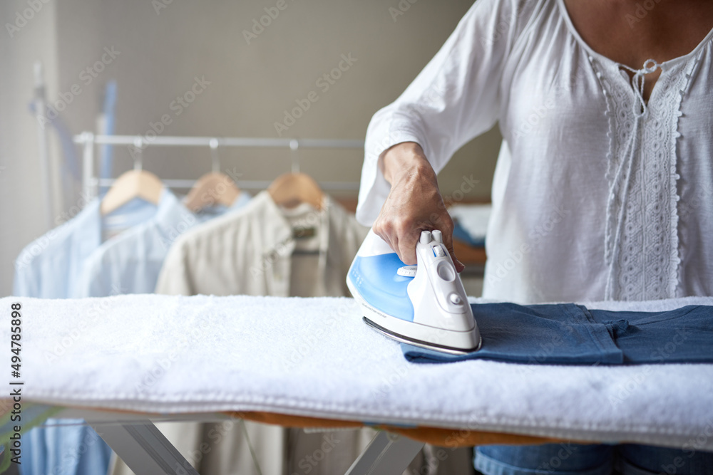 This shirt will soon be creaseless. Closeup of a woman ironing a shirt.