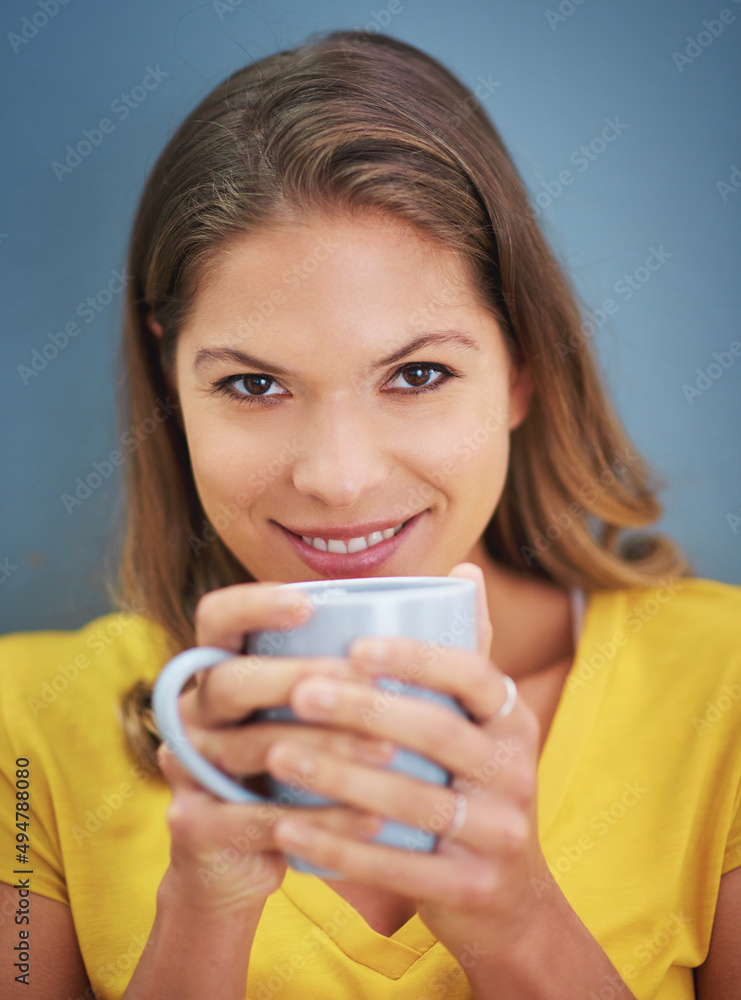 Forget love, fall in coffee. Portrait of a young woman drinking a cup of coffee against a grey backg