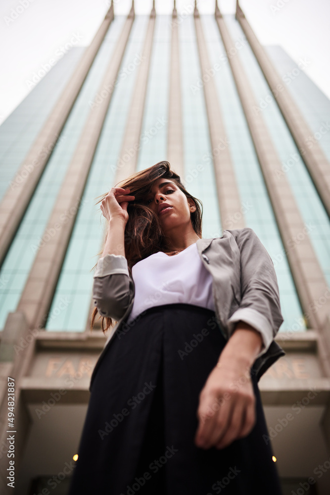 You can call me Confidence. Low angle portrait of an attractive young woman standing outdoors in the